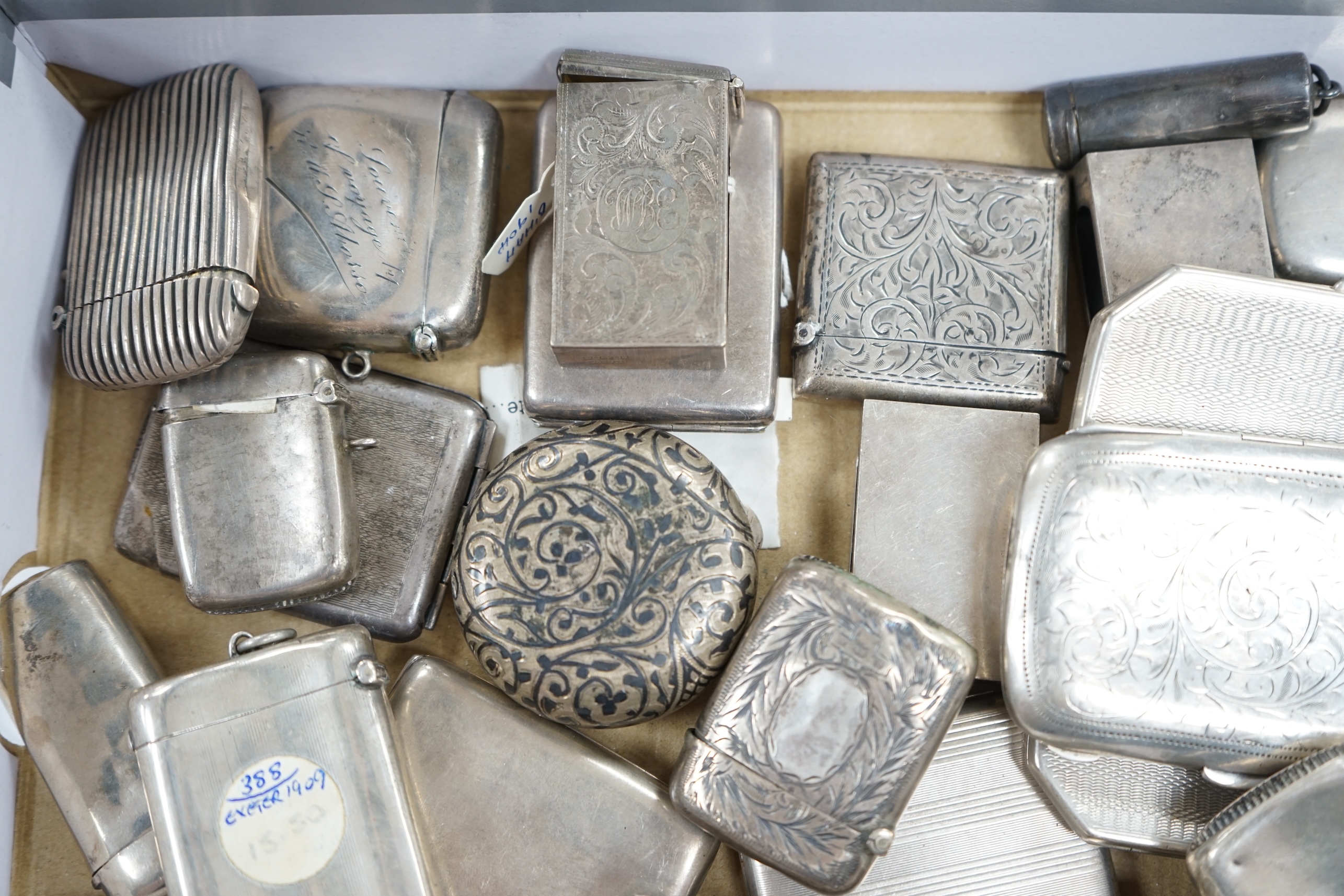 A collection of twenty four assorted silver vesta cases, eight cigarette cases, two match sleeves and a late 19th century Russian 84 zolotnik niello small tobacco box. Condition - poor to fair